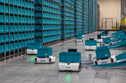 Exotec skypod robots carrying teal totes in front of storage system