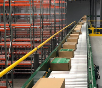 Sealed boxes on conveyor with orange racking in the background