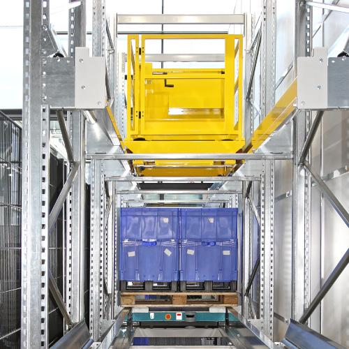 Yellow shuttle system retrieving blue tote from metal racking