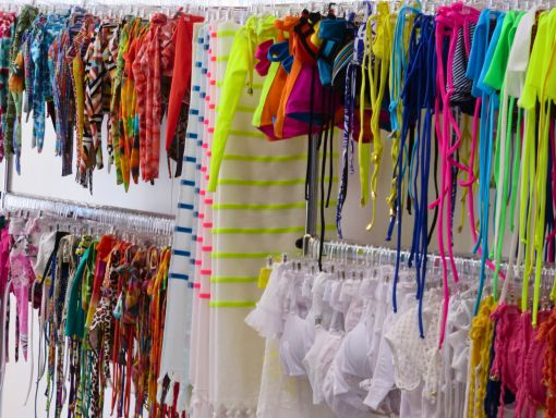 Upper and lower racks of bathing suits and beach wear in a retail store