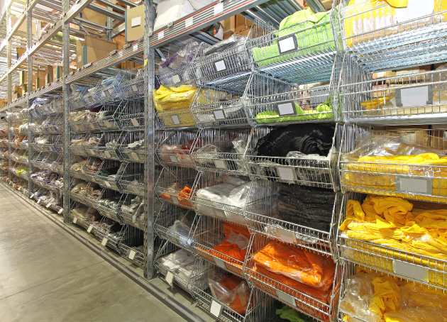 Metal storage bins with multi-colored shirts in warehouse